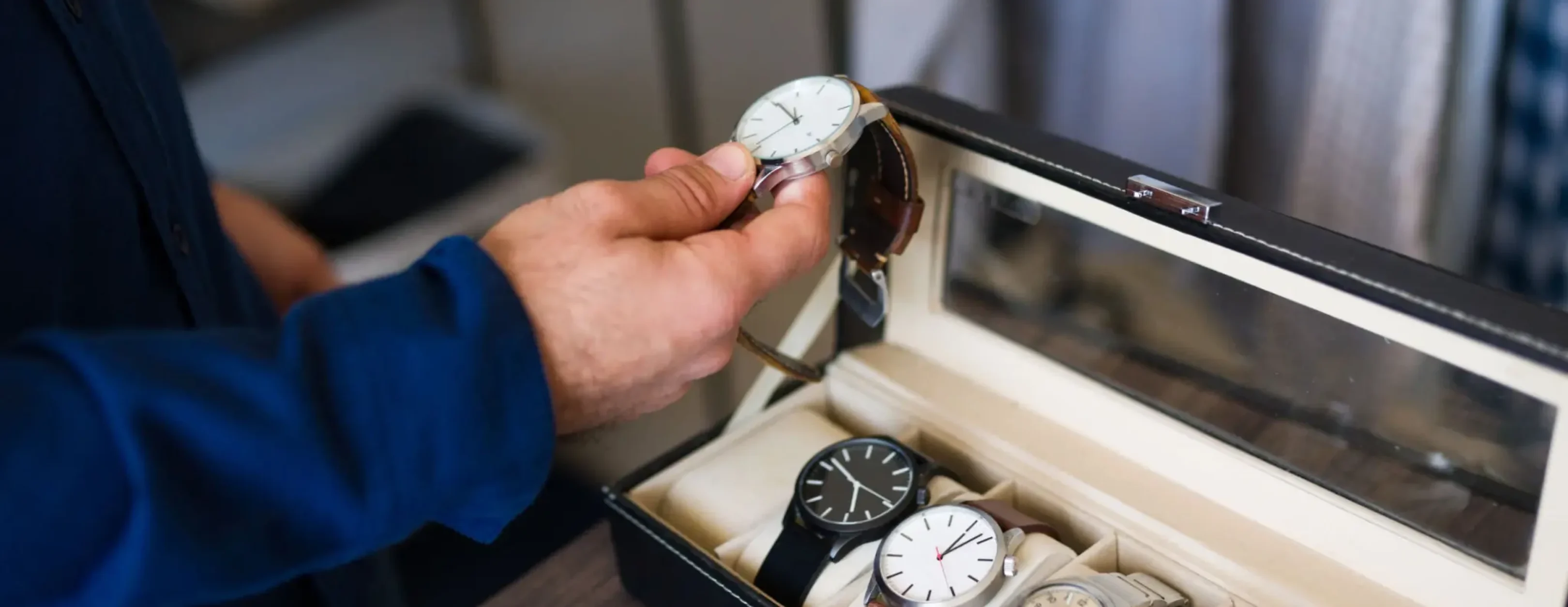 Person selecting a watch from case